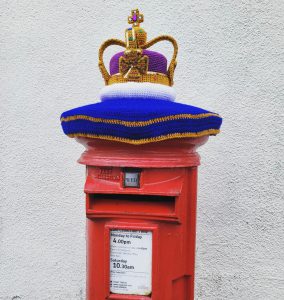 A knitted crown on the top of the pillar box outside Barlborough Post office from the Queen's jubilee - it can be won in our raffle